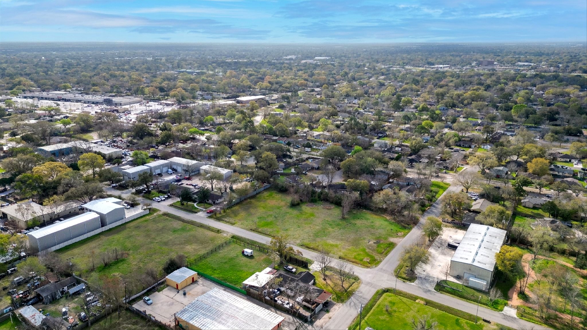 Wide aerial view of Cypress Street development sites with Houston skyline visible in background